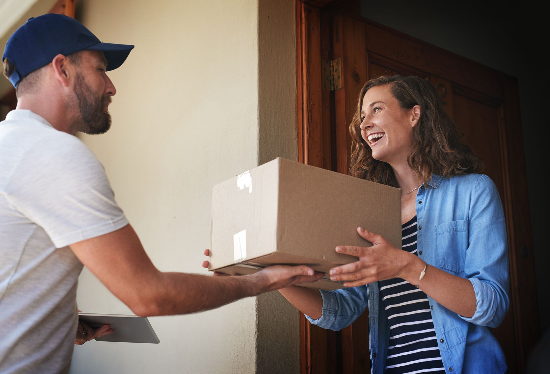 Man delivering a box to a woman Customers getting their orders on time dues to an order management system